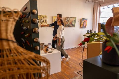 A man and woman explore Visual Index art gallery in Winston-Salem's downtown arts district.