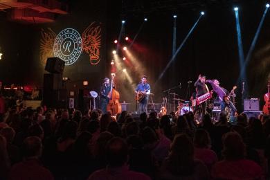 A band plays a live show on stage at The Ramkat