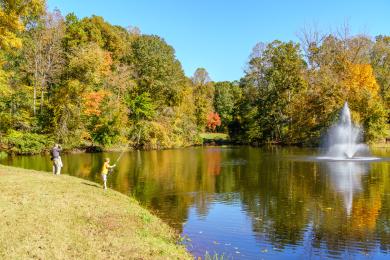 A father and son enjoy fishing at Tanglewood Park during the fall.